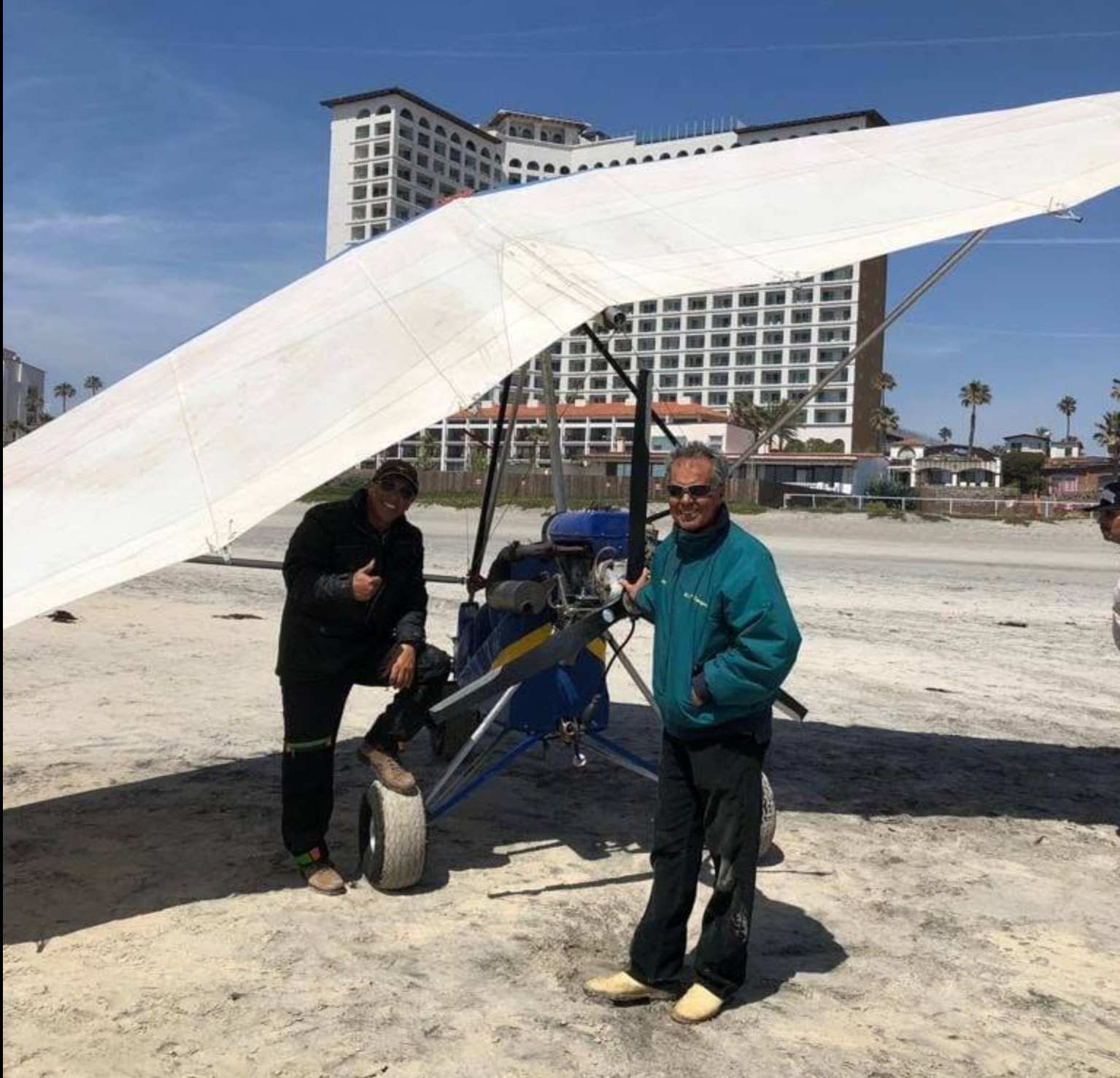 Equipo de Aguiluchos Vuelo junto al ultraligero en la playa de Rosarito