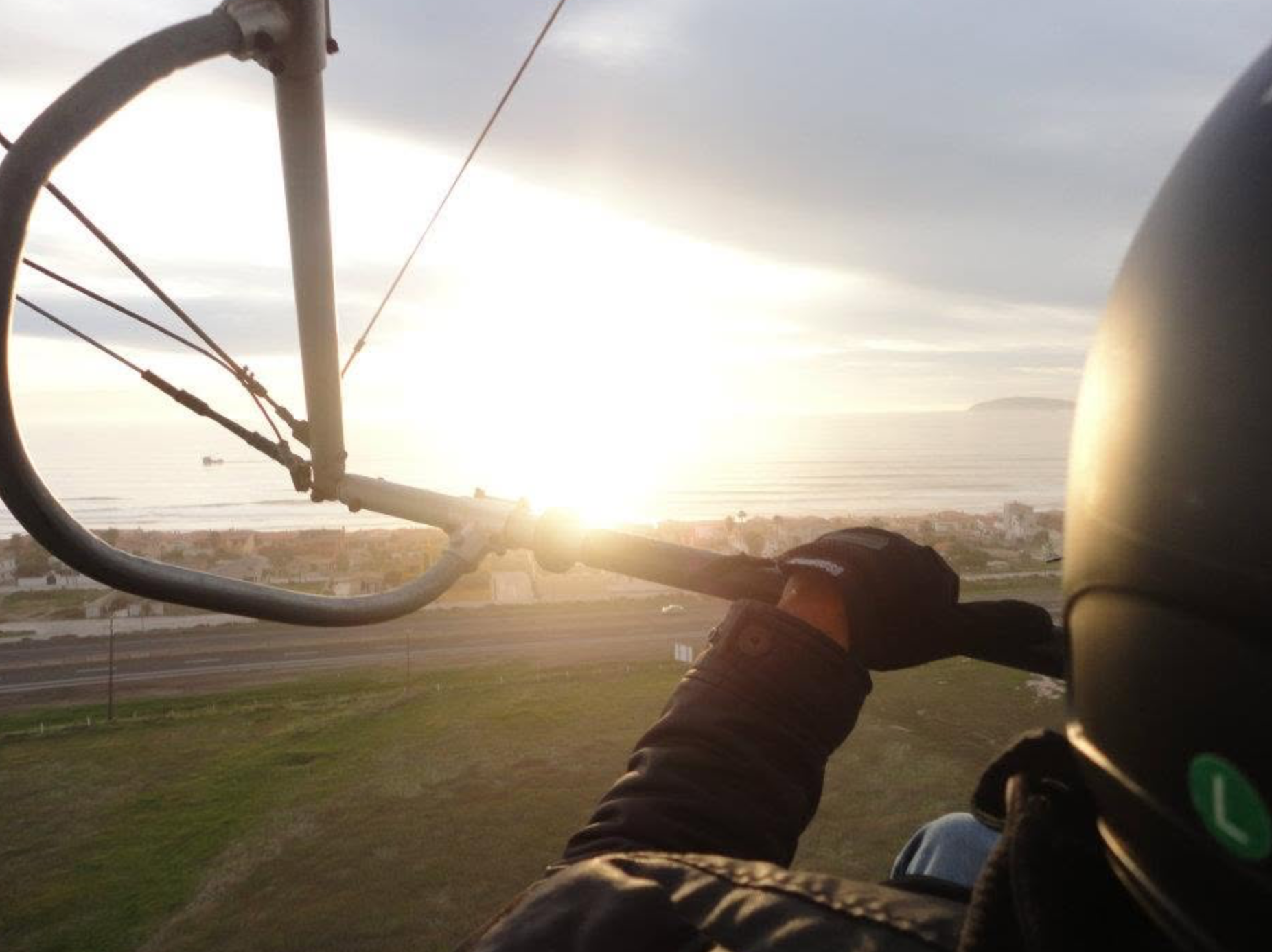 Piloto conduciendo el ultraligero al atardecer sobre Rosarito